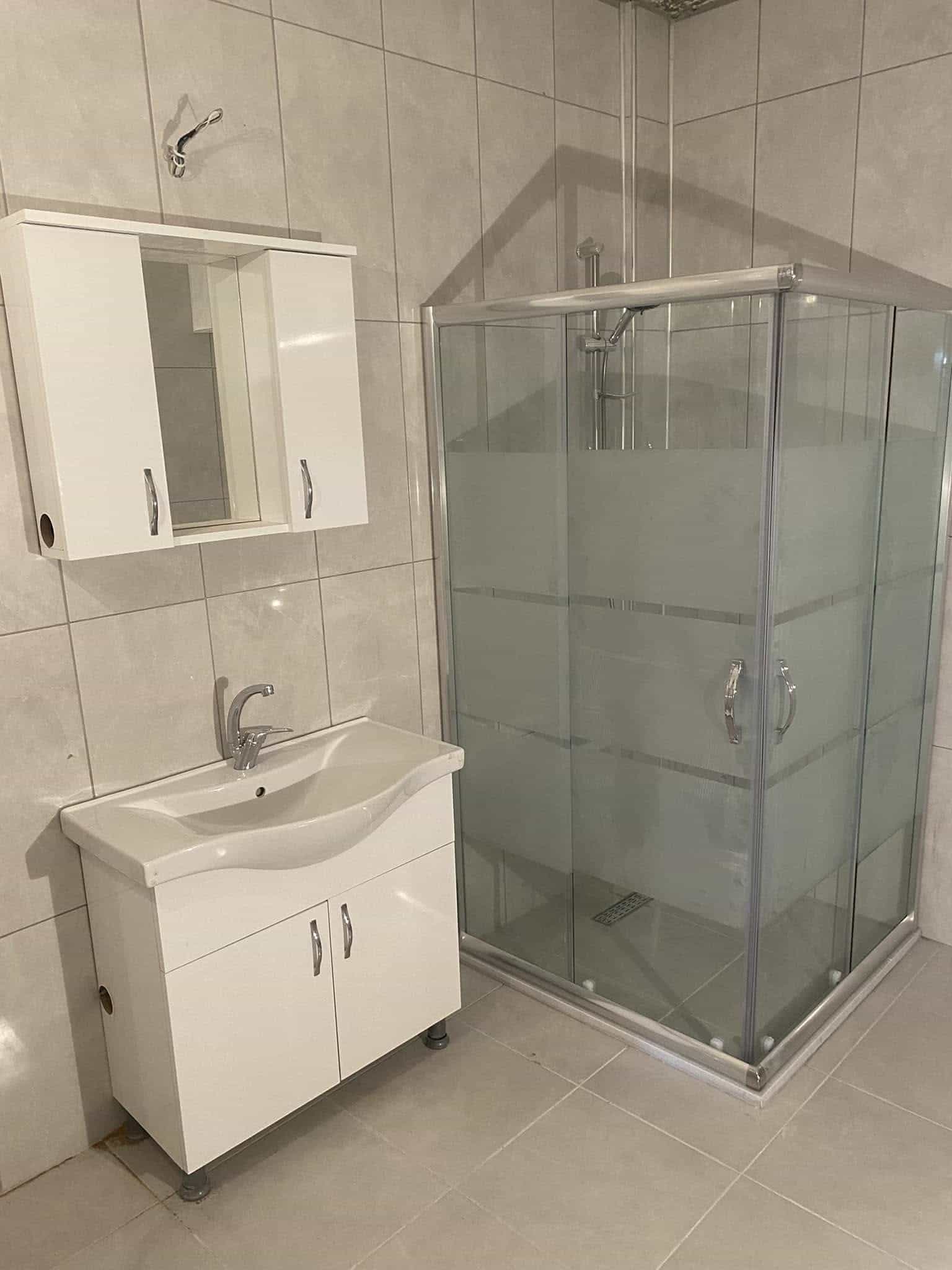 Cam duşakabin ve beyaz banyo dolabı